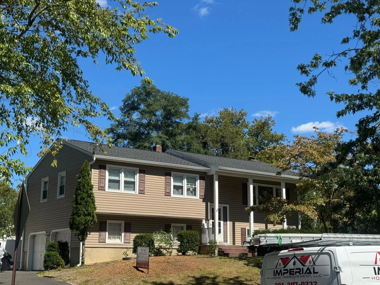 Brick colonial house with a newly installed shingle roof